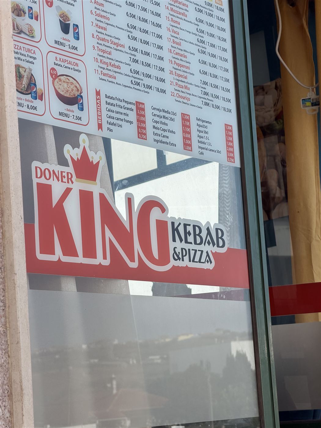 O letreiro do Doner King Kebab & Pizza na montra, na R. Dom Sancho I 3